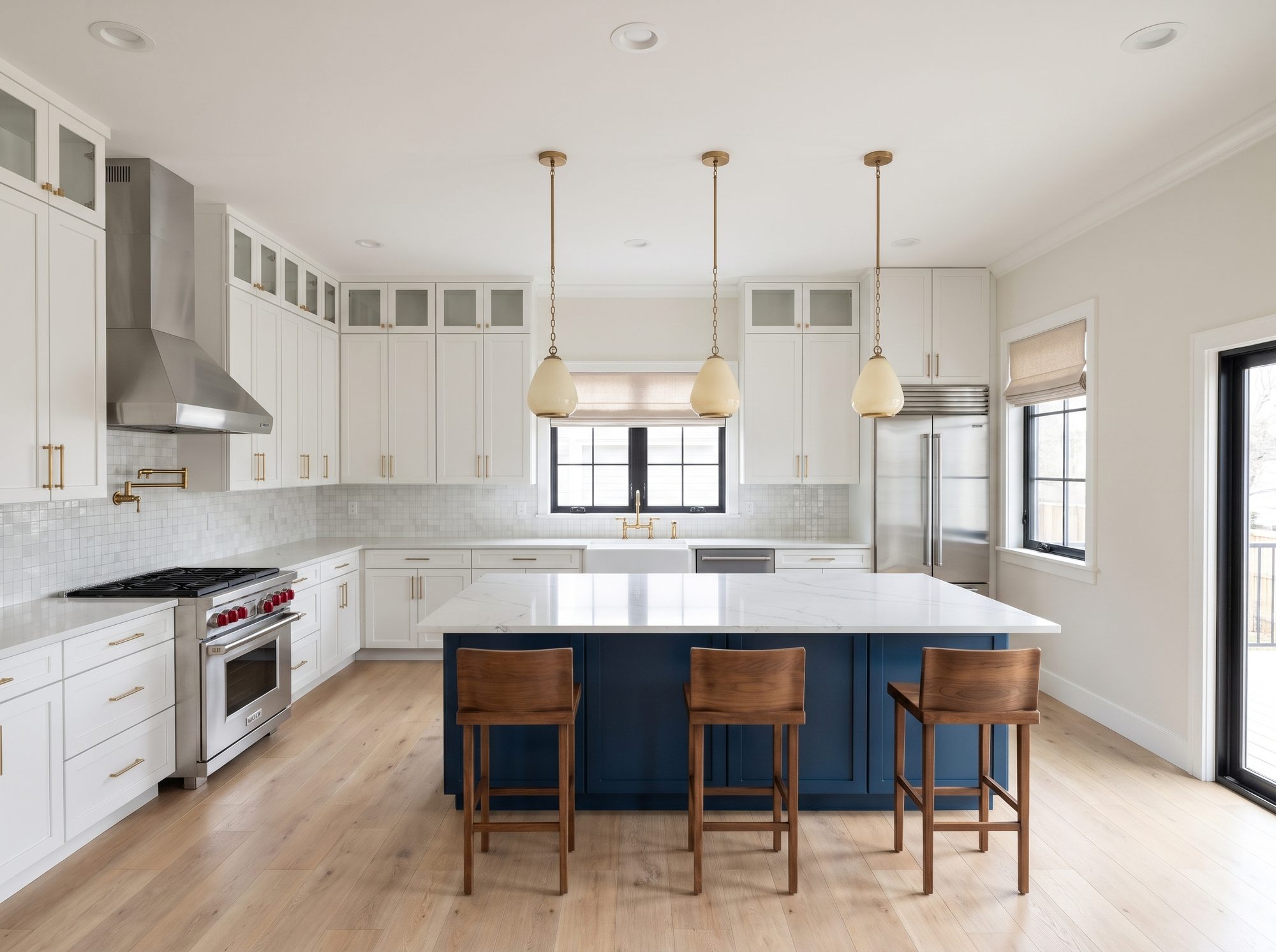 Photoreal transitional kitchen with white shaker cabinets, a navy island, brass pendants and white oak floors, rendered in Bella Design Studio